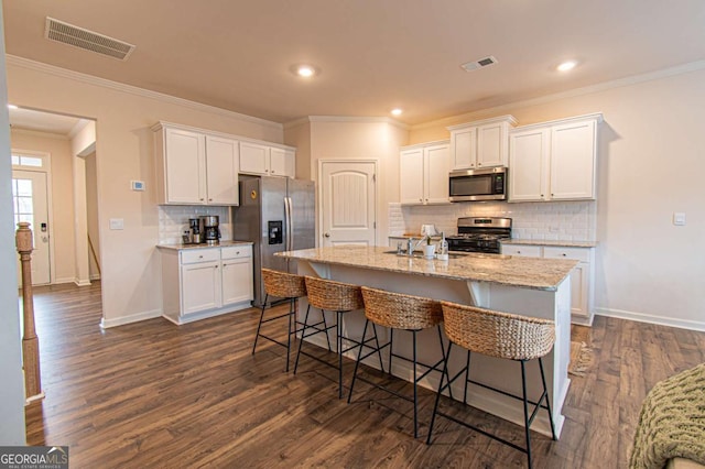 kitchen featuring appliances with stainless steel finishes, visible vents, and white cabinets