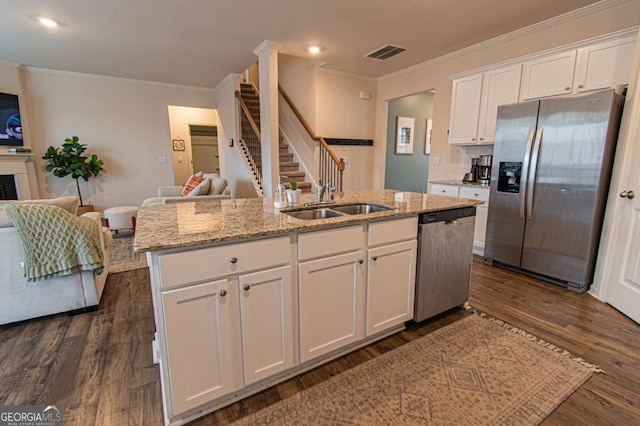 kitchen with dark wood-style flooring, white cabinetry, open floor plan, appliances with stainless steel finishes, and light stone countertops