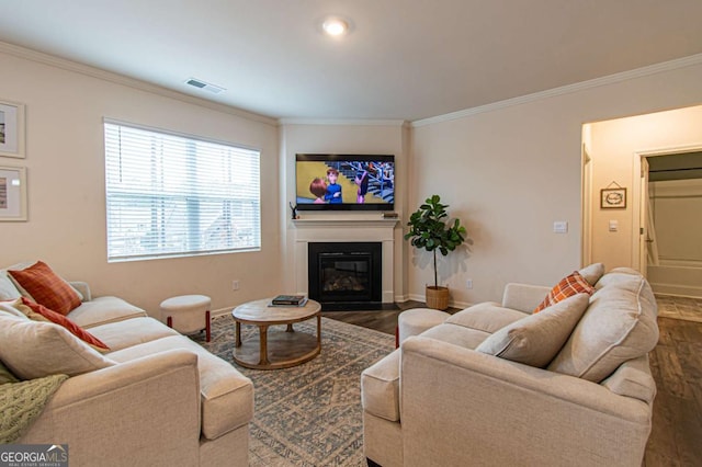 living room featuring ornamental molding, wood finished floors, a glass covered fireplace, and baseboards