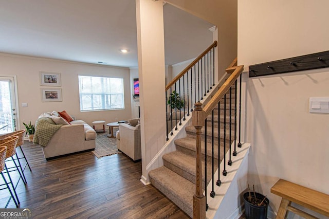 staircase with hardwood / wood-style floors, plenty of natural light, and crown molding