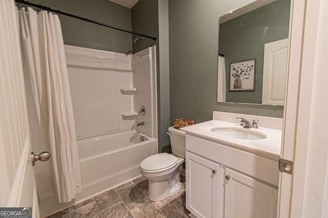 bathroom featuring stone finish flooring, shower / bath combo, vanity, and toilet