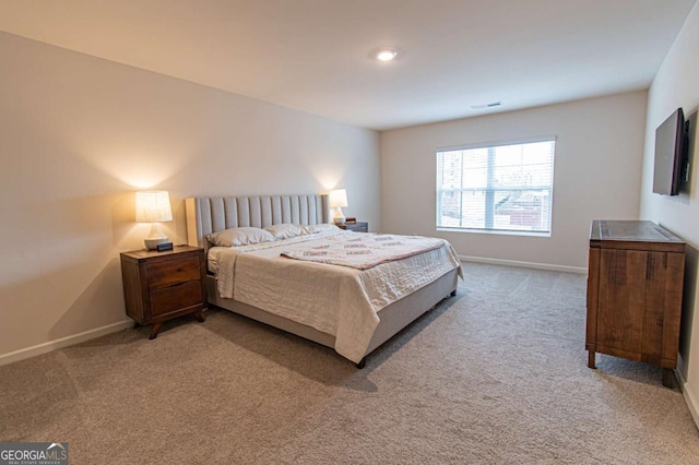 bedroom with light carpet, visible vents, and baseboards