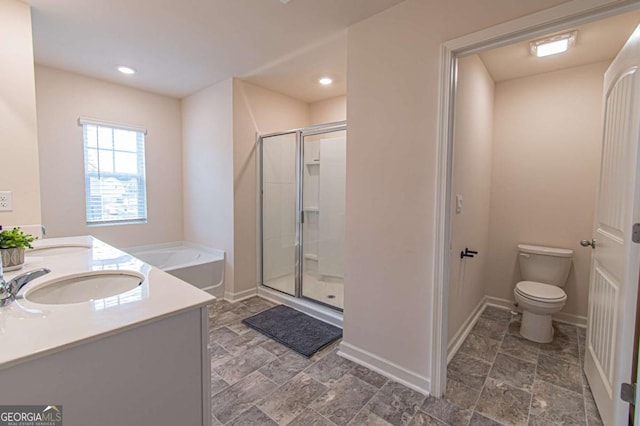 bathroom featuring baseboards, a sink, toilet, and a shower stall