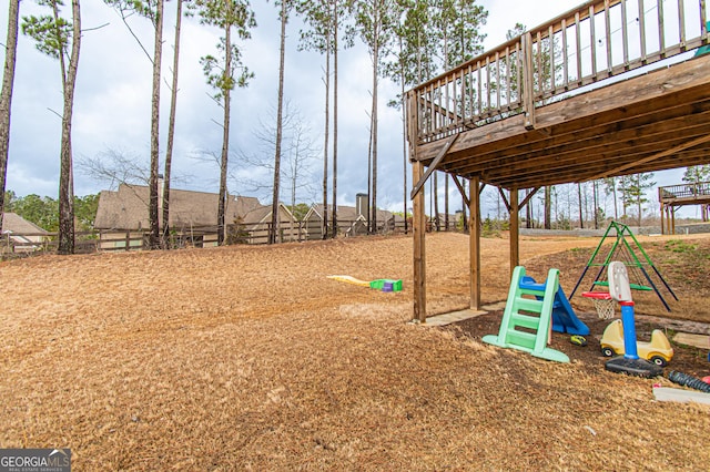 view of playground with fence and a wooden deck