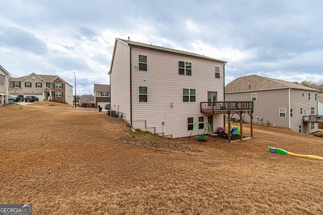 back of property featuring a residential view, a wooden deck, and central air condition unit