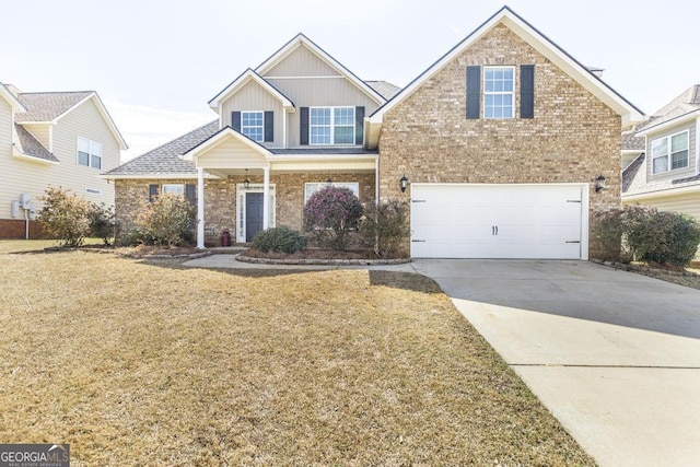 view of front of home with an attached garage, a front yard, concrete driveway, and brick siding