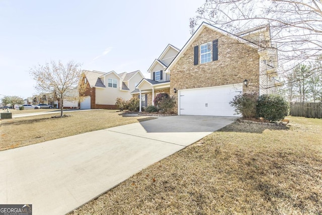 traditional-style house with brick siding, a front yard, fence, a garage, and driveway