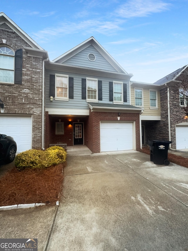 townhome / multi-family property featuring brick siding, an attached garage, and concrete driveway