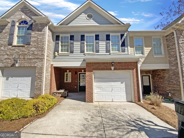 multi unit property with a garage, brick siding, and driveway