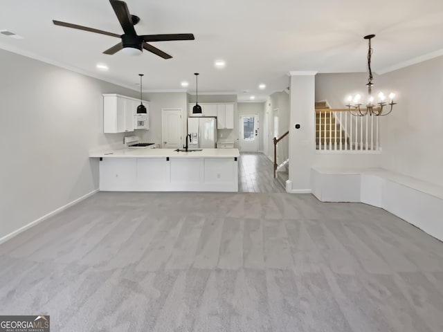 kitchen featuring ornamental molding, a sink, white appliances, a peninsula, and light countertops
