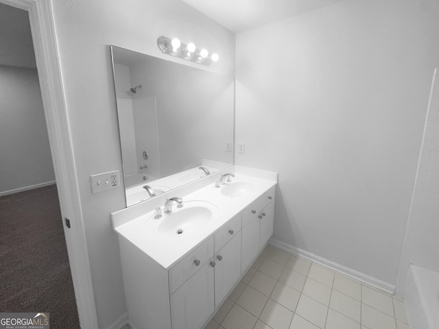 full bath with double vanity, shower / bath combination, baseboards, and a sink