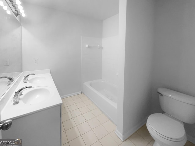 bathroom with tile patterned floors, toilet, baseboards, and a sink