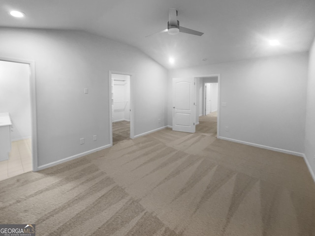 unfurnished bedroom featuring baseboards, carpet floors, recessed lighting, vaulted ceiling, and a spacious closet