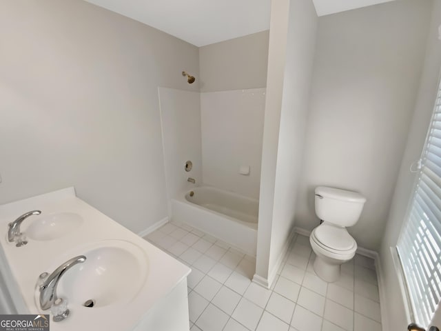 bathroom featuring tile patterned floors, toilet, a sink, washtub / shower combination, and baseboards