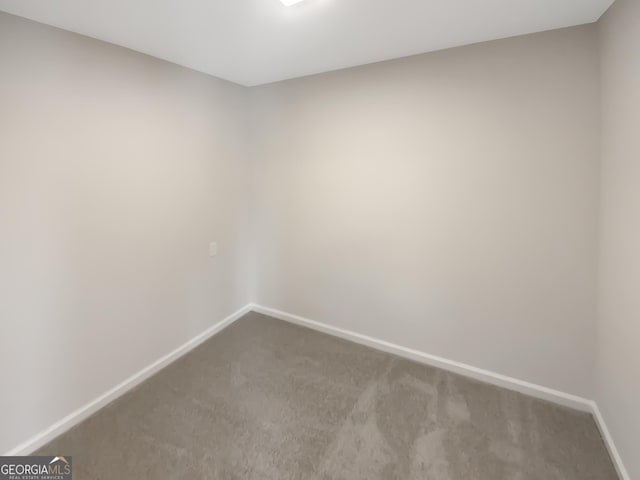 carpeted empty room featuring baseboards