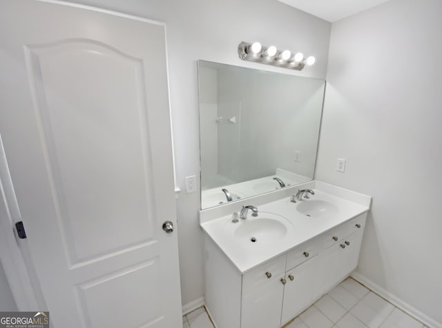 bathroom featuring double vanity, baseboards, and a sink