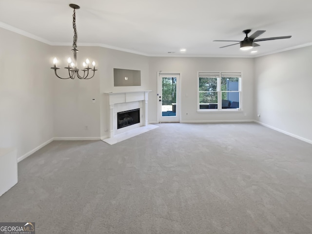 unfurnished living room featuring a high end fireplace, ceiling fan with notable chandelier, crown molding, and baseboards