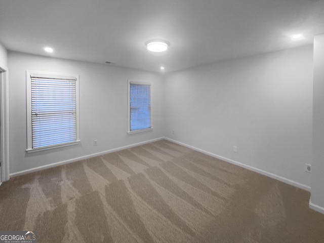 carpeted empty room featuring recessed lighting and baseboards