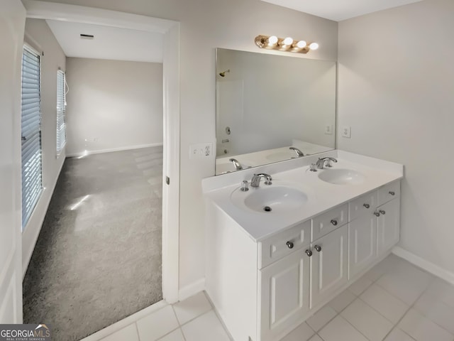 bathroom with a sink, baseboards, and double vanity