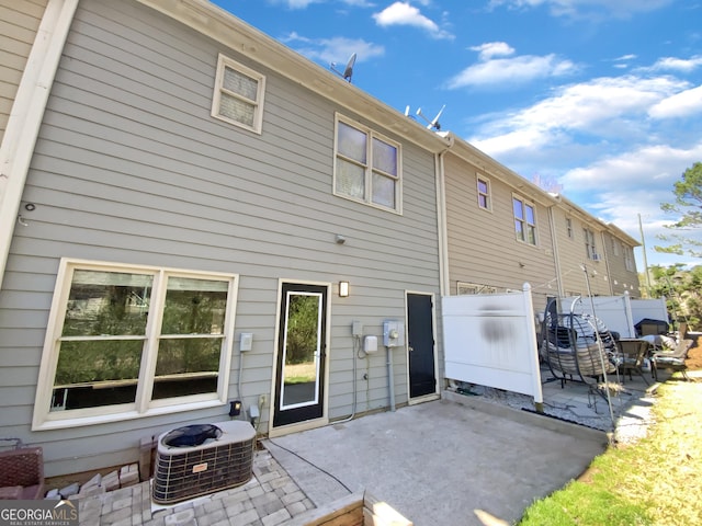 rear view of property featuring a patio, cooling unit, and fence