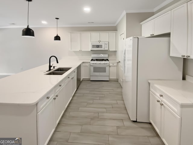 kitchen with white appliances, a peninsula, ornamental molding, a sink, and white cabinetry