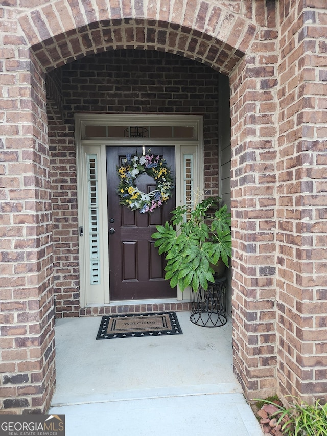 property entrance featuring brick siding