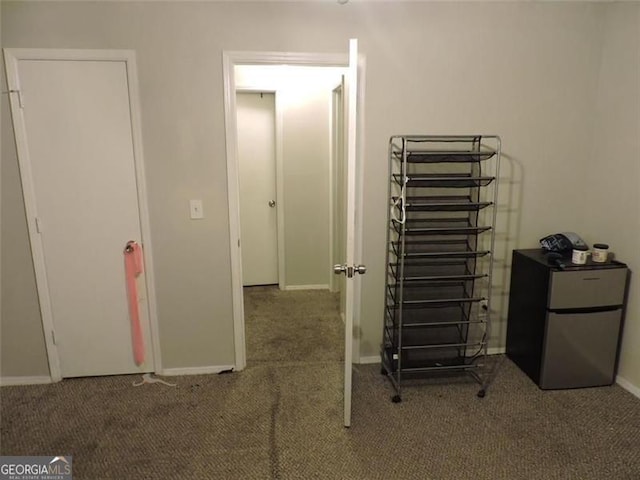 interior space featuring baseboards, carpet flooring, and refrigerator