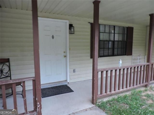 view of exterior entry featuring covered porch