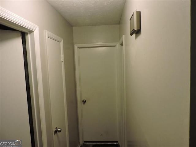 hallway with a textured ceiling