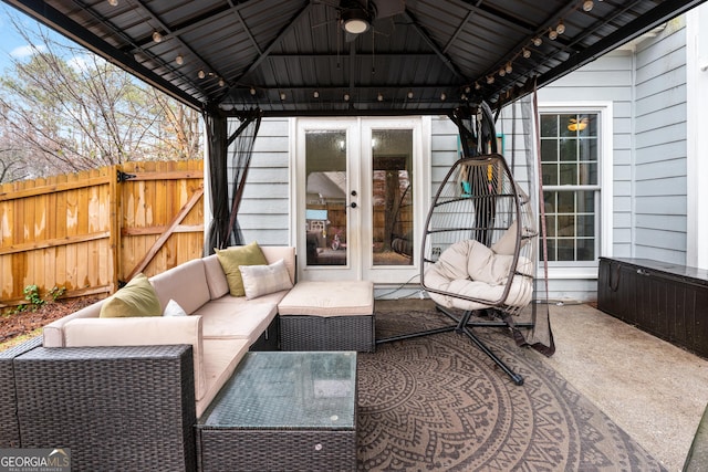 view of patio featuring a gazebo, fence, an outdoor living space, and ceiling fan