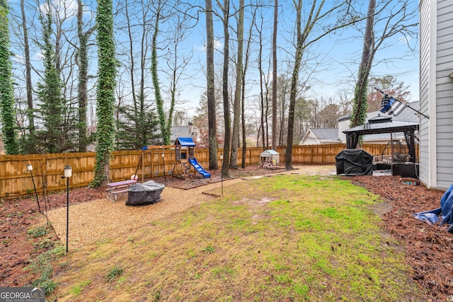 view of yard featuring a gazebo, a fire pit, a fenced backyard, and a playground