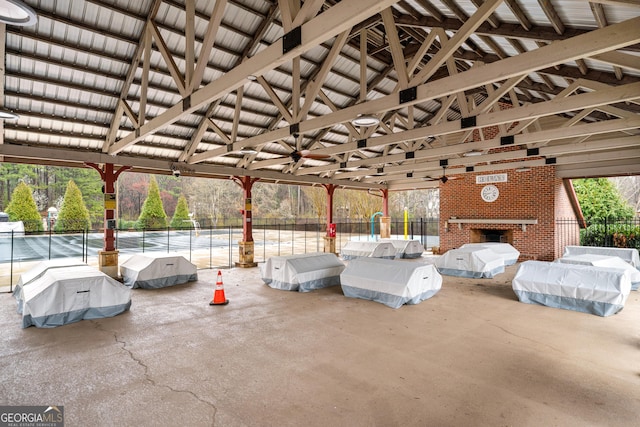 view of patio with an outdoor brick fireplace and fence