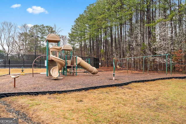 community jungle gym with a yard and fence