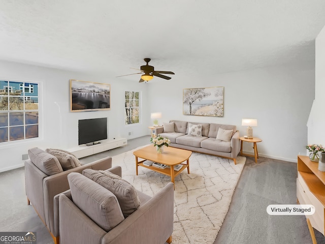 living area with baseboards and a ceiling fan