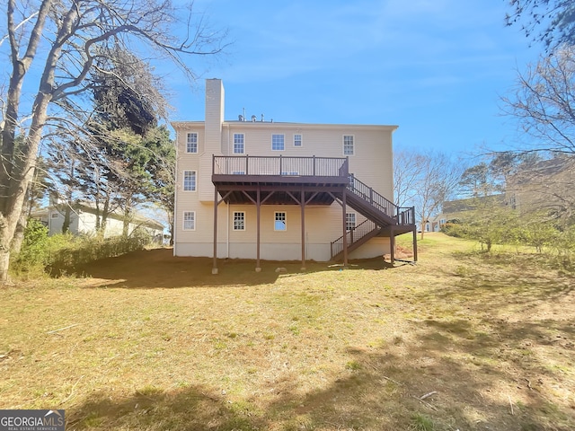 rear view of house featuring a deck, stairway, a lawn, and a chimney