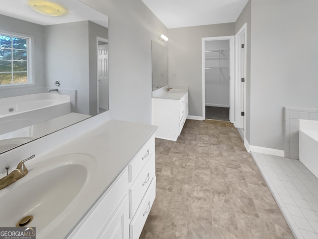 full bath featuring baseboards, a spacious closet, a bath, and vanity