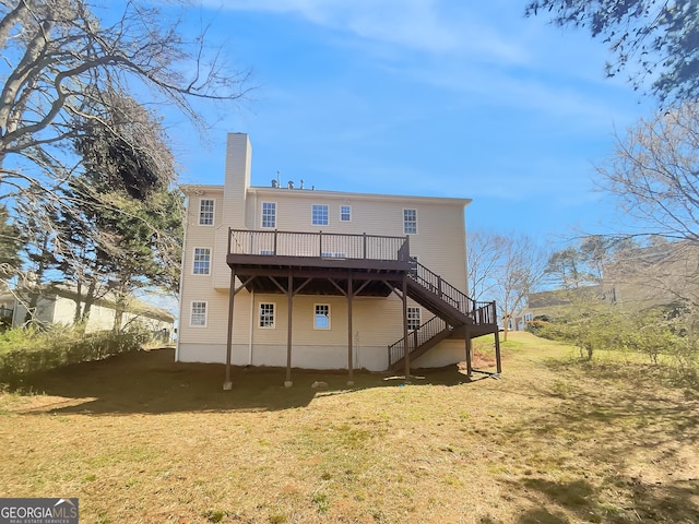 rear view of house featuring stairs, a wooden deck, a yard, and a chimney