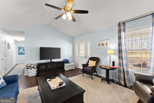 living area with lofted ceiling, a textured ceiling, a ceiling fan, and wood finished floors