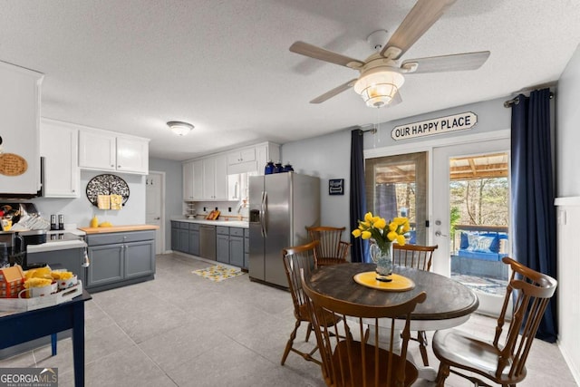 dining room featuring light tile patterned floors, a ceiling fan, and a textured ceiling