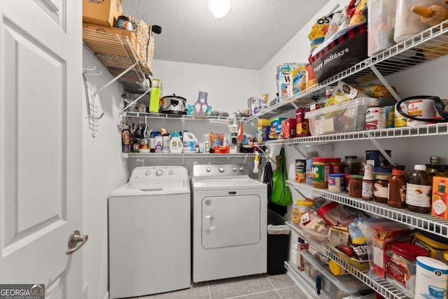 laundry room featuring laundry area, light tile patterned floors, a textured ceiling, and separate washer and dryer