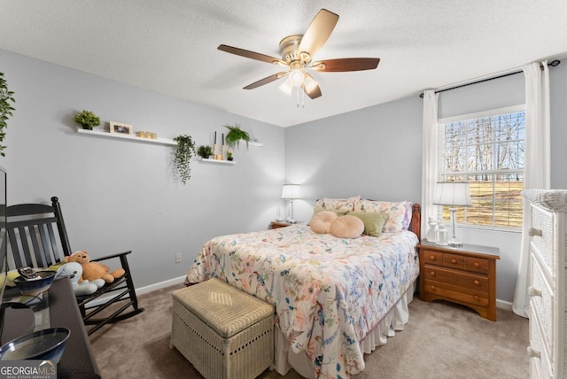 carpeted bedroom featuring a ceiling fan, baseboards, and a textured ceiling