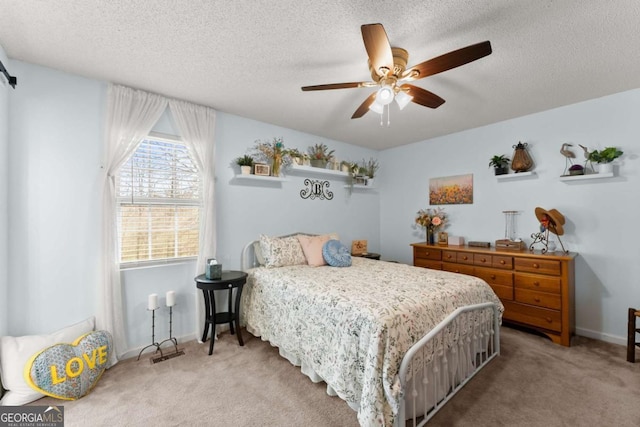 carpeted bedroom featuring ceiling fan, a textured ceiling, and baseboards