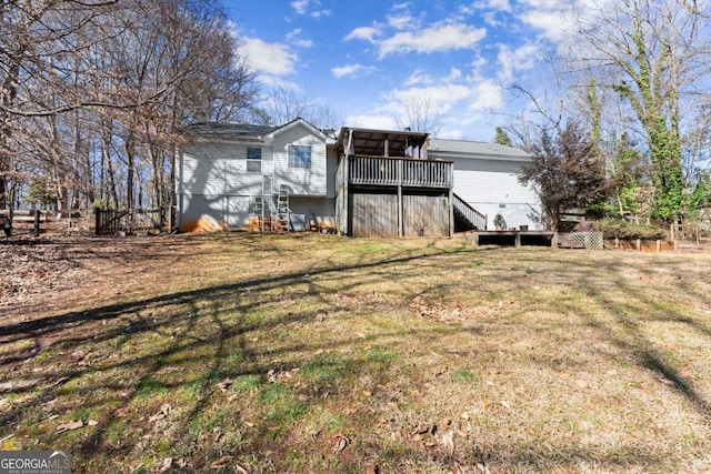 rear view of property featuring a lawn and a wooden deck