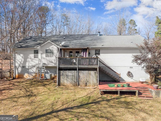 rear view of property featuring crawl space, stairway, a deck, and a yard