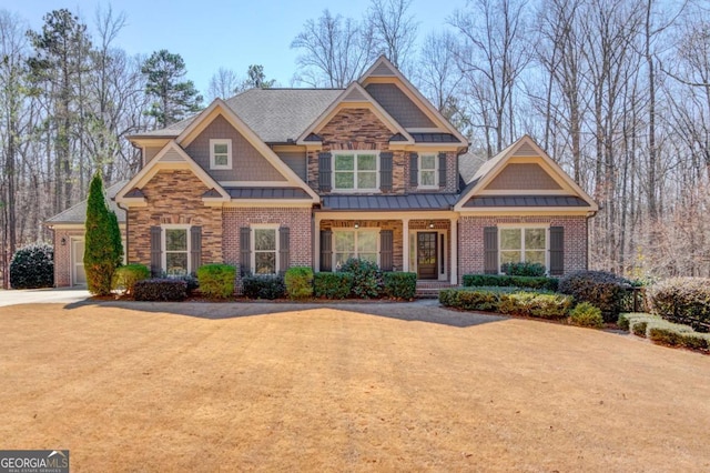 craftsman-style house featuring metal roof, driveway, and a standing seam roof