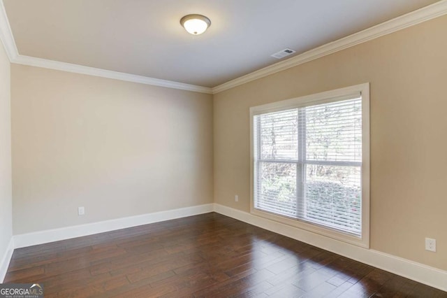 spare room with crown molding, dark wood finished floors, visible vents, and baseboards