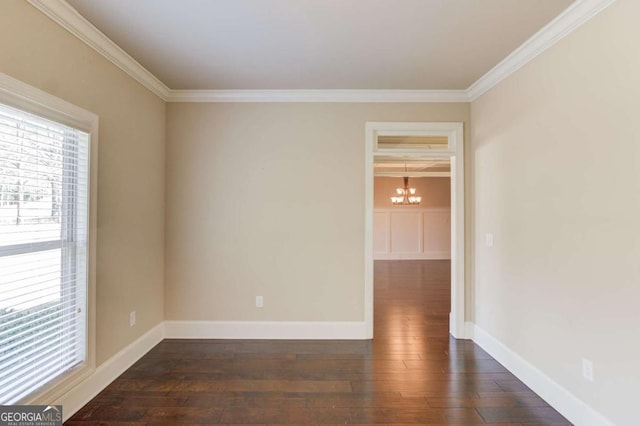 unfurnished room with dark wood-style floors, ornamental molding, a chandelier, and baseboards