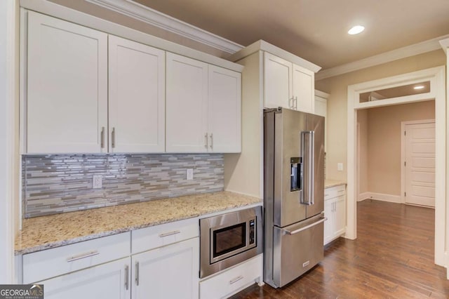 kitchen featuring crown molding, stainless steel appliances, backsplash, dark wood-type flooring, and white cabinetry