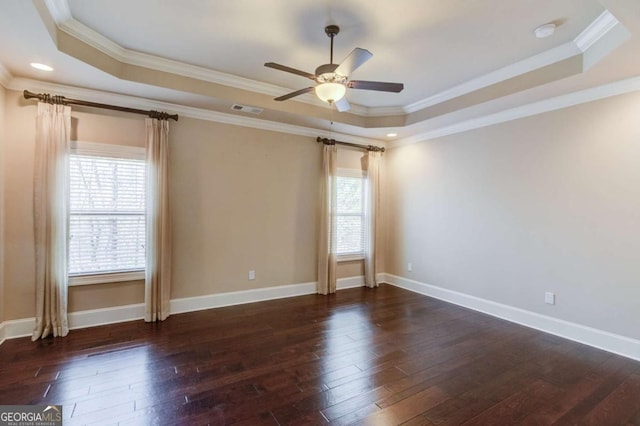 unfurnished room featuring a tray ceiling, a healthy amount of sunlight, visible vents, and wood finished floors