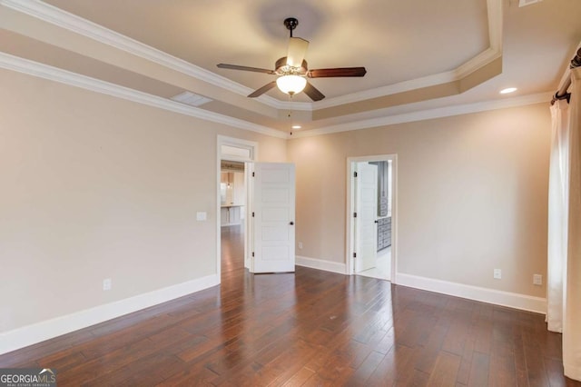 interior space with hardwood / wood-style floors, a raised ceiling, and baseboards